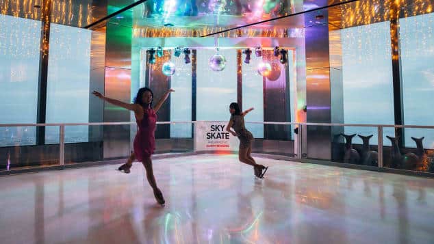 Patinoire intérieure Sky Skate avec deux femmes faisant du patin à glace