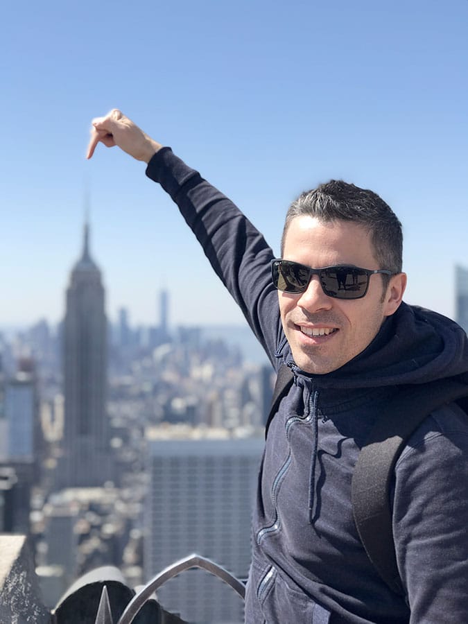 Homme devant l'Empire State Building depuis le Top of the Rock