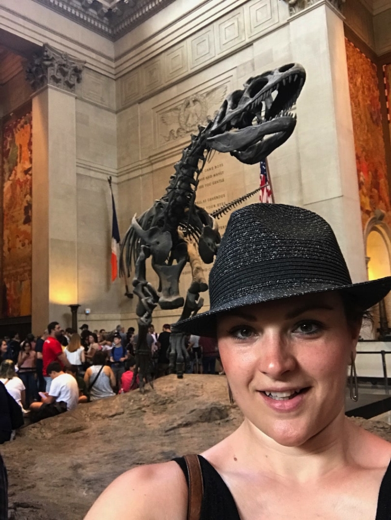 Femme devant un squelette de dinosaure au musée d'histoire naturelle de New York.