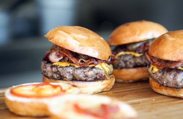 3 burgers sur une table avec des pains ouverts à l'avant