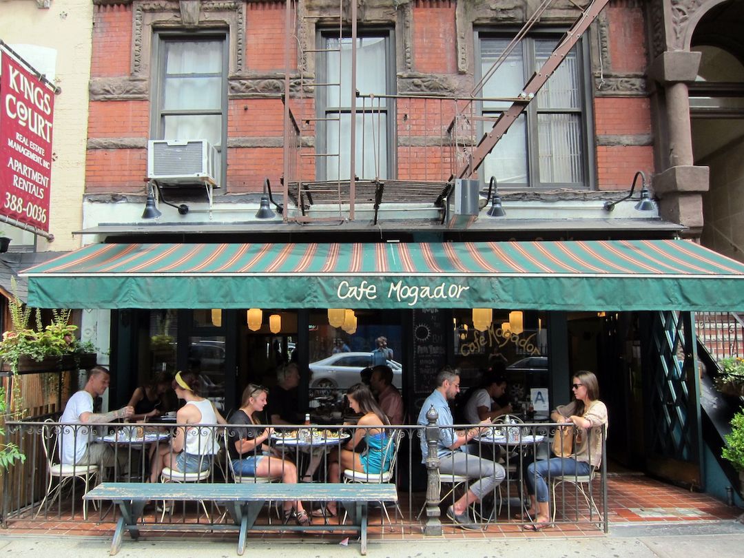Terrasse du Café Mogador avec des personnes assises aux tables à l'extérieur
