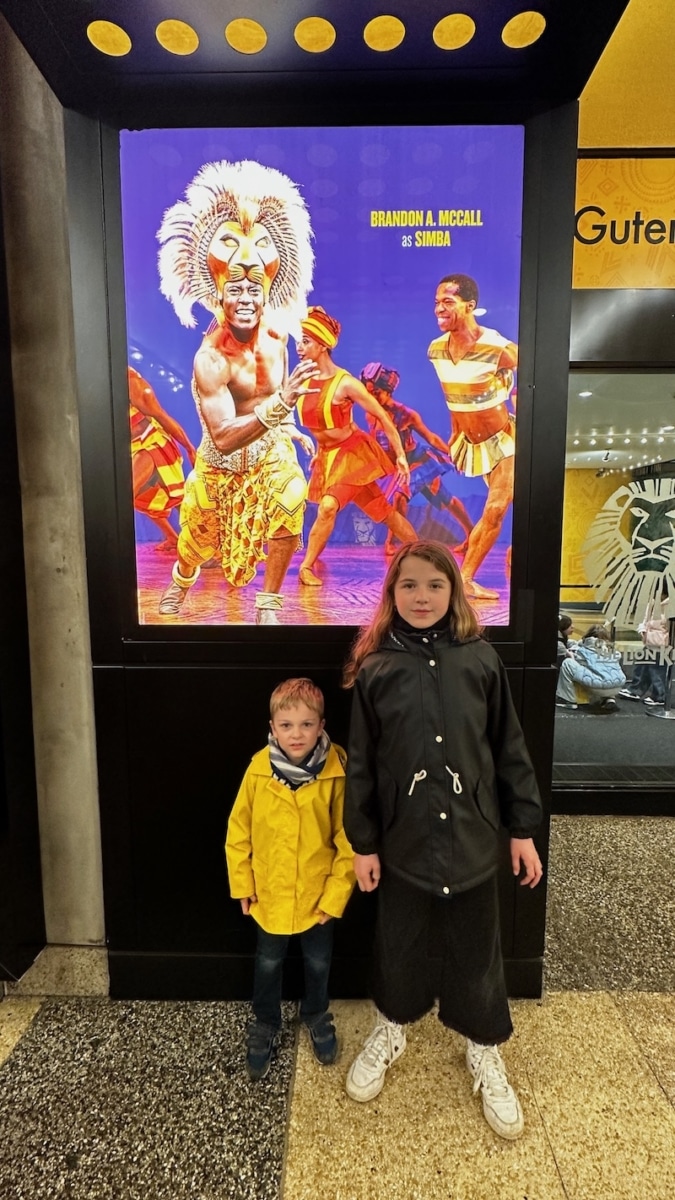 Enfants qui posent devant une affiche de la comédie musicale à New York