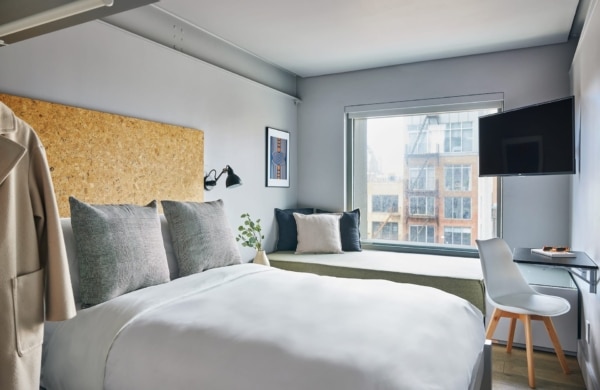 Chambre double de l'appart-hôtel de Lantern Lower East Side avec une bue sur la rue.